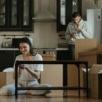 Młoda para rozpakowuje kartony w małej kuchni wynajmowanego mieszkania