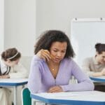 Młodzież pisze egzamin w szkolnej sali