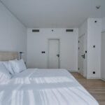 Nowoczesna, neutralna sypialnia w mieszkaniu na wynajem