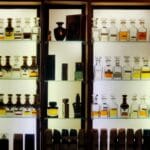 Flakony luksusowych perfum niszowych na podświetlanych półkach