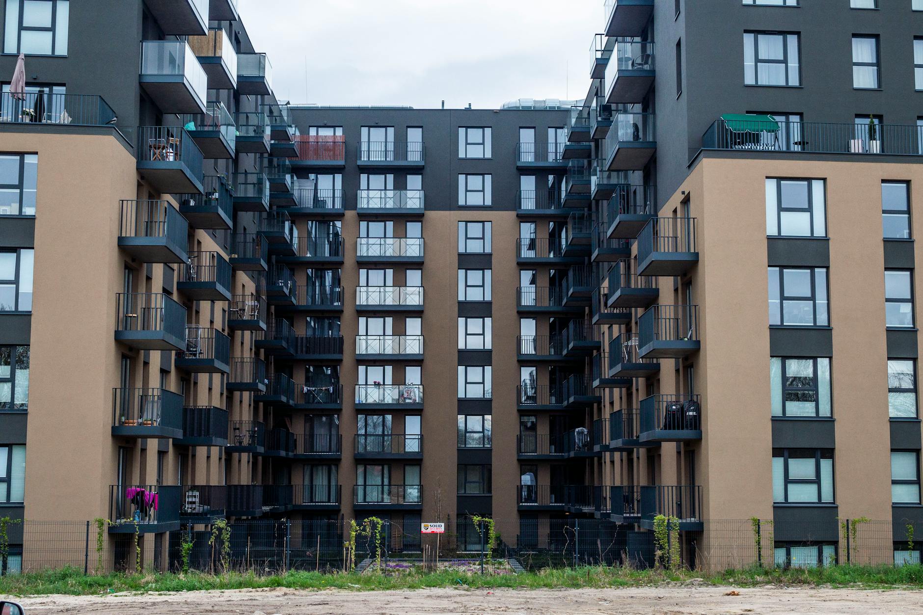 Nowoczesna elewacja bloku z balkonami na osiedlu w miejskiej zabudowie