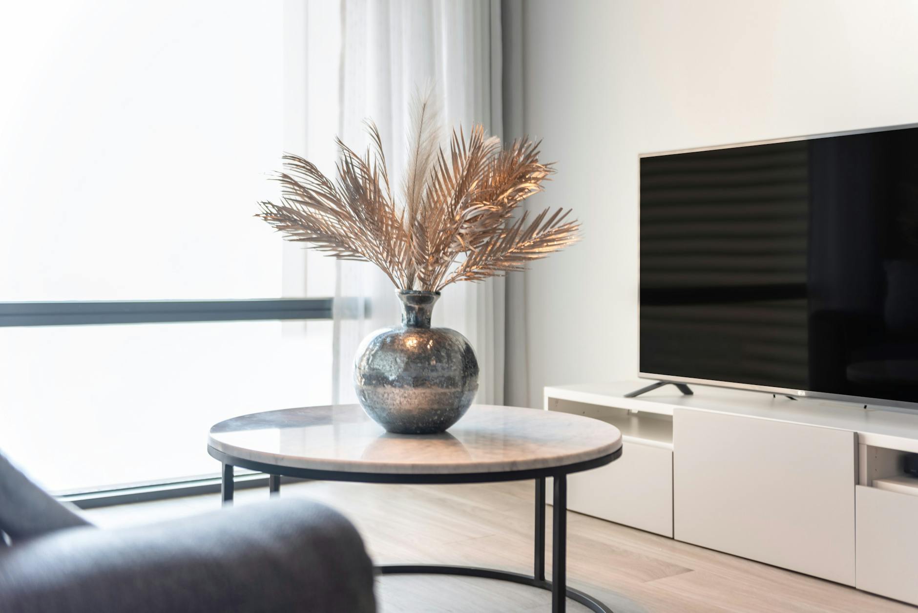 Czy warto zostawiać telewizor w mieszkaniu na wynajem i jak go wkomponować we wnętrze Salon w mieszkaniu na wynajem z telewizorem i stolikiem z wazonem