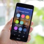 Dłoń trzyma smartfon z aplikacją do zarządzania inteligentnym domem