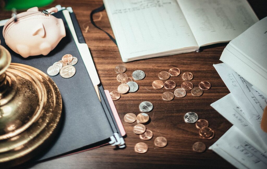 Monety, dokumenty finansowe i skarbonka na biurku księgowego